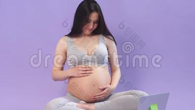 怀孕女商人正<strong>在做瑜伽</strong>，看笔记本电脑上的视频