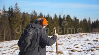 年轻徒步<strong>旅行</strong>者带着背包和手杖在田野的雪山上攀爬的侧面景色。 在雪地上徒步<strong>旅行</strong>的<strong>运动</strong>员
