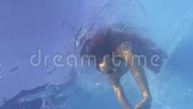 一名身穿红色连衣裙的年轻女子潜入水中的水下镜头，4k