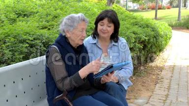 同情的<strong>看护</strong>者教这位白发苍苍的老年妇女如何在社交网络中使用平板电脑