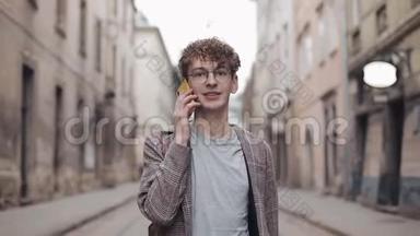年轻的嬉皮士戴眼镜笑着在智能<strong>手机</strong>上说话，看着他的<strong>手表</strong>，在博客上约会散步