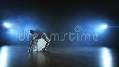 现代芭蕾舞演员的戏剧旋转和翻转从音乐剧。 单身女子在舞台上与一个