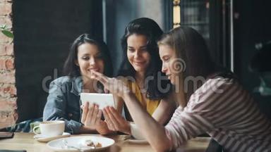 快乐的女孩看着智能手机屏幕，微笑着在咖啡馆里玩得开心
