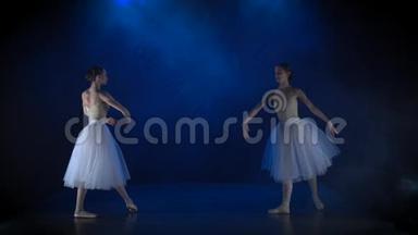 两个穿白色芭蕾舞裙的芭蕾舞演员表演古典芭蕾。 慢动作。