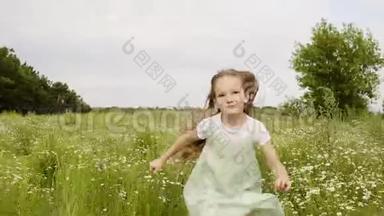 兴奋的女孩在夏天的战场上运行前置摄像头。 女孩把绿草扔到花草坪上拍照。 微笑的女孩