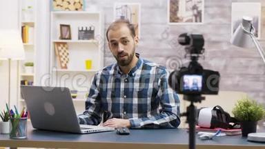 著名年轻的vlogger说话时在笔记本电脑上打字