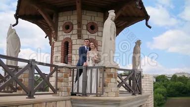 新婚夫妇走过一座古老的石堡，里面有宏伟的石像。