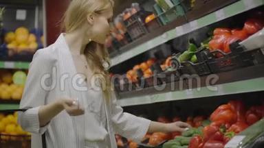 在<strong>超市</strong>里挑选黄瓜和<strong>蔬菜</strong>的女人。 购物选择购买<strong>水果</strong>，<strong>蔬菜</strong>。 少女