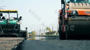 正在<strong>施工</strong>的阿斯普拉特公路。 一台机器在<strong>铺设</strong>沥青时骑在路上。