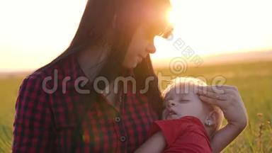 年轻漂亮的<strong>妈妈</strong>和婴儿一起在公园里散步。 小女儿睡在一位有爱心的母亲的<strong>怀里</strong>