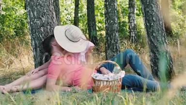 浪漫的野餐时间。 快乐的年轻夫妇接吻。 男人趴在她的手上.. 公园的户外活动