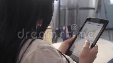 女孩制作网上销售购物概念与笔记本电脑生活方式数字平板电脑。 黑发女人躺在沙发上看着商店