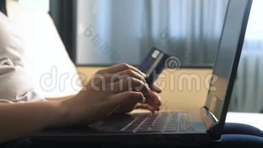 女孩用笔记本电脑数字平板电脑制作网上销售购物概念。 黑发女人躺在沙发上看网上商店