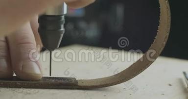 一个皮革工艺品€™手工钻洞在皮革支架上与一个钻。 手工制品。 <strong>电影</strong>院4k视频。 C4k