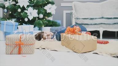 可爱的<strong>视频</strong>小男孩睡在<strong>圣诞树</strong>下的白色地毯上，在圣诞节前，卷曲。