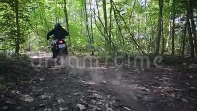 摩托车上穿着防护装备的运动员Enduro启动时，尘土和泥土从车轮下飞扬
