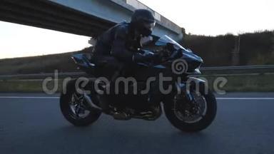 男子骑现代运动摩托车在高速公路与太阳耀斑背景。 骑摩托车的摩托车