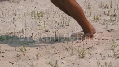 <strong>缺水</strong>的人在热天在热沙上散步。 男人的腿`沙子上。 慢动作