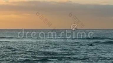 孤帆船在夕阳的强烈阳光下漂浮在地平线上。 浪漫，孤独的概念