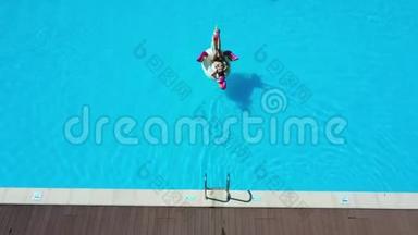 空中射击。 穿比基尼的女孩和戴着<strong>充气</strong>床垫的太阳镜在游<strong>泳池</strong>里游泳。