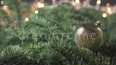 <strong>圣诞树</strong>上金色的<strong>装饰</strong>球，放在<strong>圣诞树</strong>茂盛的树枝上，背景是闪烁的花环