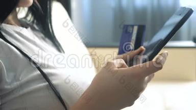 女孩制作网上销售购物生活方式概念与笔记本电脑数字平板电脑。 黑发女人躺在沙发上看着商店