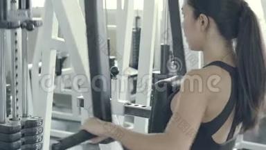 美丽的亚洲年轻女子健身训练臂在健身房健身