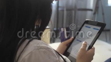女孩制作网上销售生活方式购物概念与笔记本电脑数字平板电脑。 黑发女人躺在沙发上看着商店