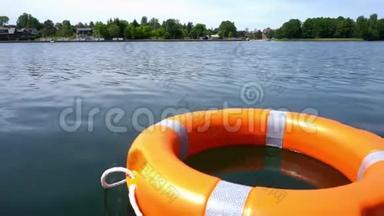 橙色救生浮标漂浮在<strong>远离</strong>海岸的湖水上。 万向节运动