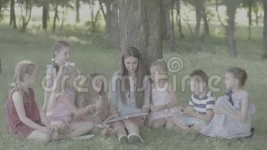 V-log。 女青年作为教育家在公园为男孩和女孩读书