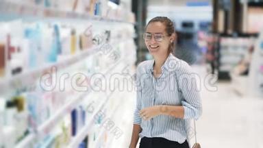 <strong>化妆品店</strong>戴眼镜的女孩站在货架前，笑着慢动作