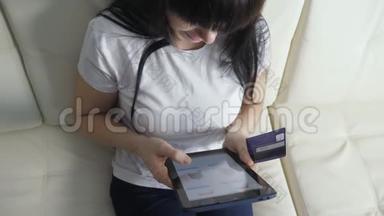 女孩用笔记本<strong>电脑</strong>数字平板<strong>电脑</strong>制作网上<strong>销售</strong>购物概念。 黑发女人躺在沙发上看店