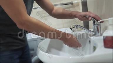 男人在浴室用自来水洗手。人吃饭前洗手。卫生防疫