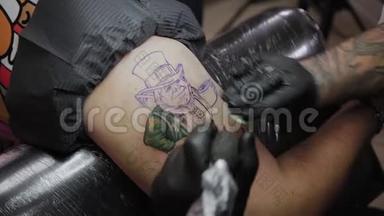 专业纹身师在男人手臂上做纹身。