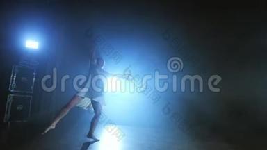 一个穿着白色连衣裙的年轻女孩在<strong>舞台</strong>上跳着现代芭蕾，烟雾缭绕在<strong>蓝色</strong>的聚光灯下。