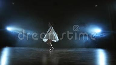一个穿着白色连衣裙的年轻女孩在<strong>舞台</strong>上跳着现代芭蕾，烟雾缭绕在<strong>蓝色</strong>的聚光灯下。