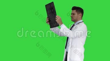 穿白色工作服的<strong>医护</strong>人员，在绿色屏幕上行走时看x射线摄影图像、ct扫描和mri