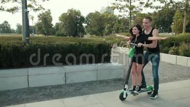 美丽的情侣，女孩和男人在公园里骑电动<strong>滑板</strong>车