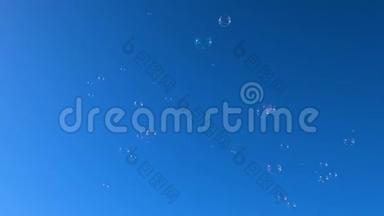 透明气泡在晴朗的蓝天背景上飞行，气泡漂浮运动4k