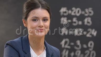 青年教师看相机，黑板上的数学方程式，特写