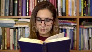 一个年轻的女<strong>人</strong>正在<strong>图书馆看书</strong>。 一个戴眼镜的女<strong>人</strong>仔细地看着这本书的特写。 在里面