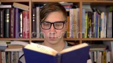 一个年轻<strong>人</strong>正在<strong>图书馆看书</strong>。一个戴眼镜的<strong>人</strong>仔细地看了看这本书的特写镜头。在后台