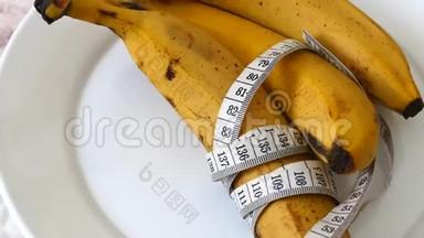 香蕉和健康减肥，香蕉和饮食，在白色背景上用卷尺测量