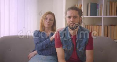 在电视上<strong>看戏</strong>剧电影的年轻夫妇在家里感到悲伤和哭泣。