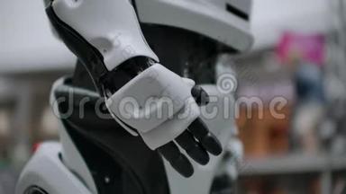 现代机器人技术。 一个男人与机器人交流，把一只塑料<strong>机械手臂</strong>按在机器人身上，握手