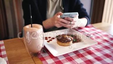 <strong>女孩</strong>编辑并发送她的菜的照片，甜点在智能手机上到<strong>社交网络</strong>。