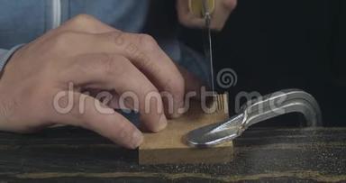 玛娜的特写€™用手锯锯木的细节。 木匠做手工木制梳子. 电影4K录像