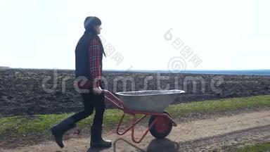 农夫女孩红脖子在泥土里工作，穿着橡胶靴的花园手推车。 农民<strong>生态农业</strong>