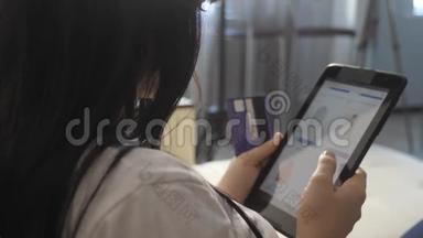 女孩制作<strong>网上销售</strong>购物概念与生活方式笔记本电脑数字平板电脑。 黑发女人躺在沙发上看着商店