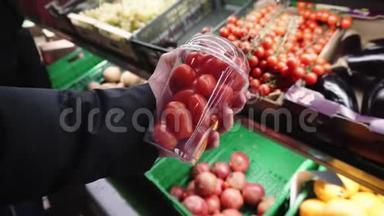 新鲜的有机番茄在一个年轻的女孩手中选择农产品在当地的超市。
